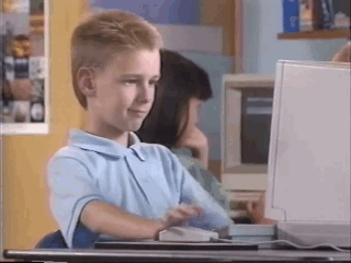 A young blond boy – apparently named Brent Rambo – giving a thumbs up after having used a mouse in front of an Apple computer